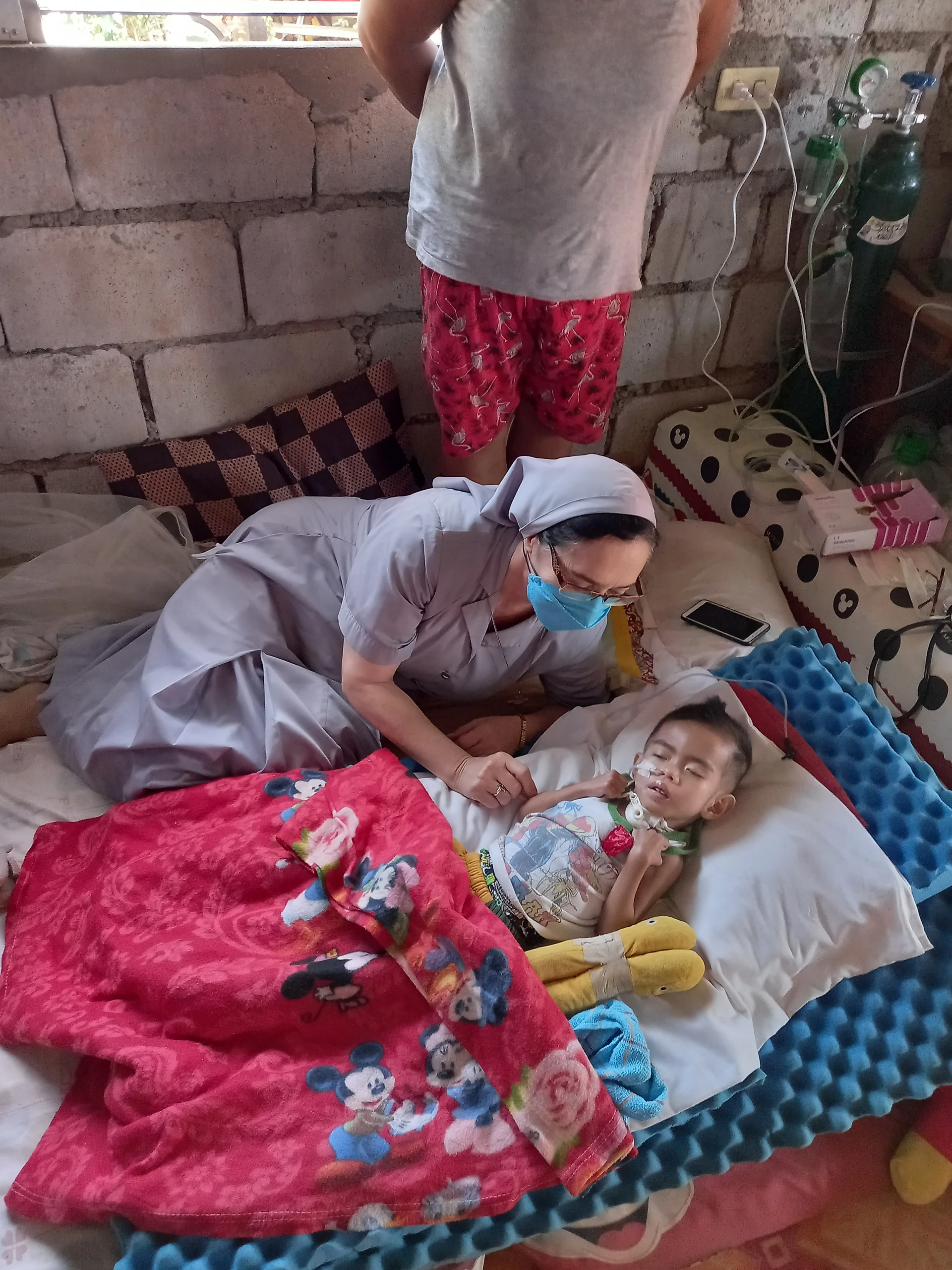 A sister visiting and assisting a community member
