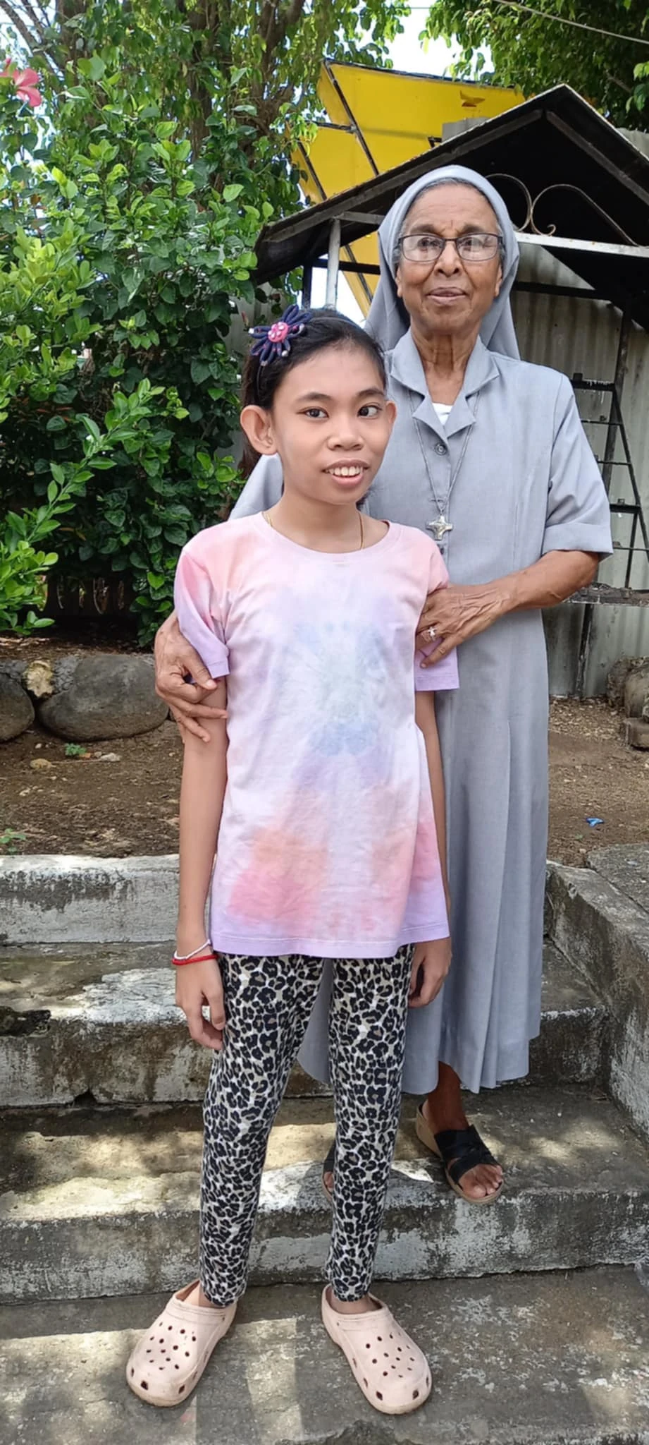 A sister outdoors alongside a child