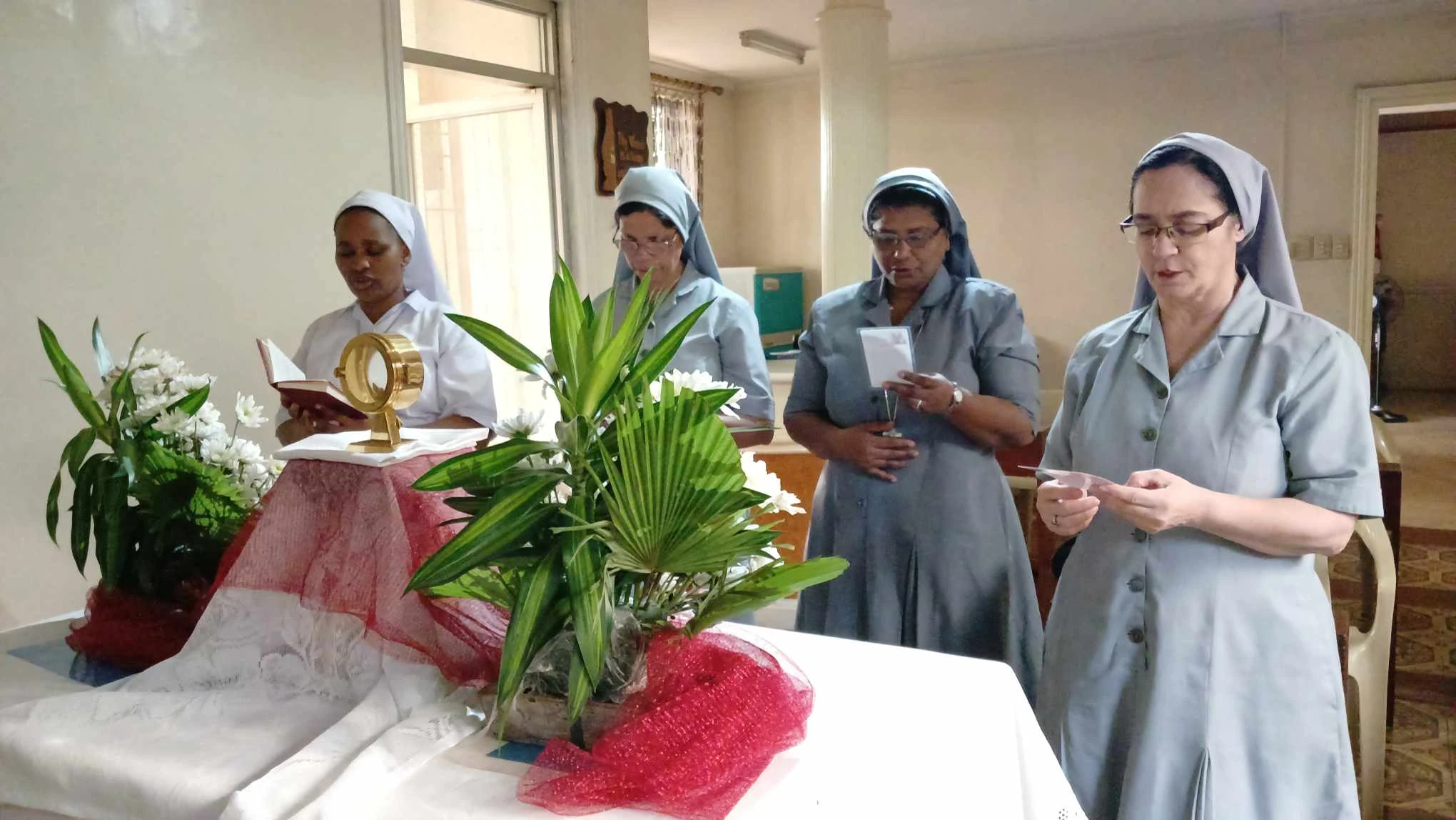 Sisters and a priest gathered at the altar during a liturgical celebration