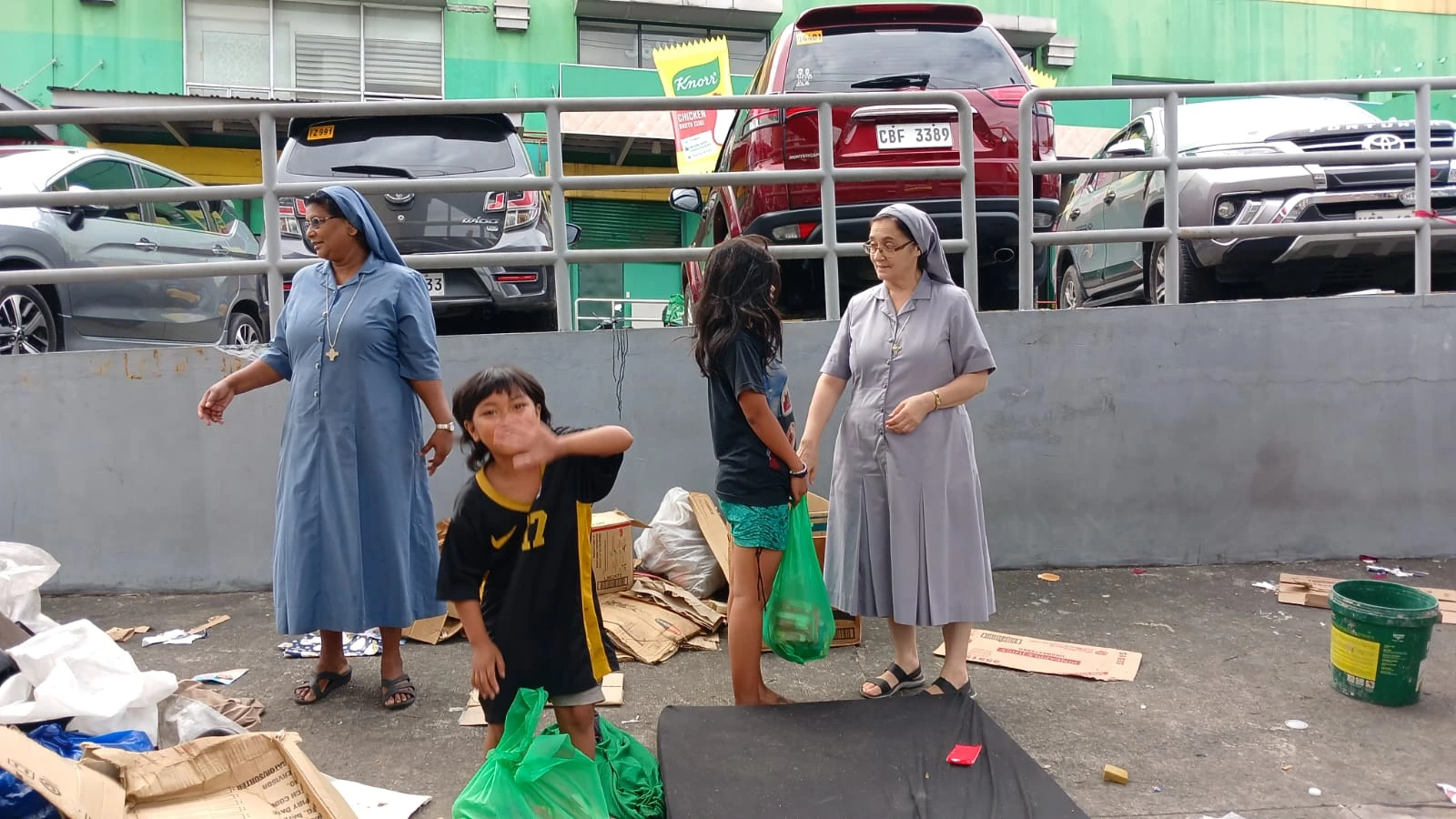 Sisters with adults and children during a distribution of practical supplies