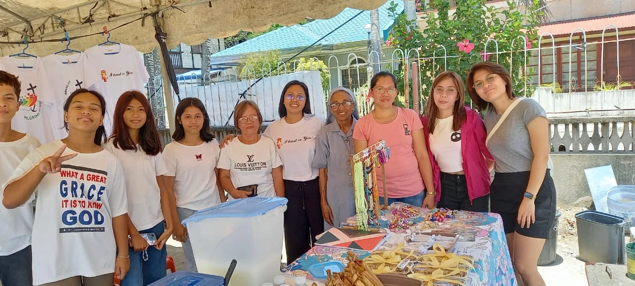 Sisters and community members gathered around a table outdoors